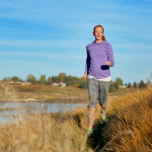 Lady hiking near a river.