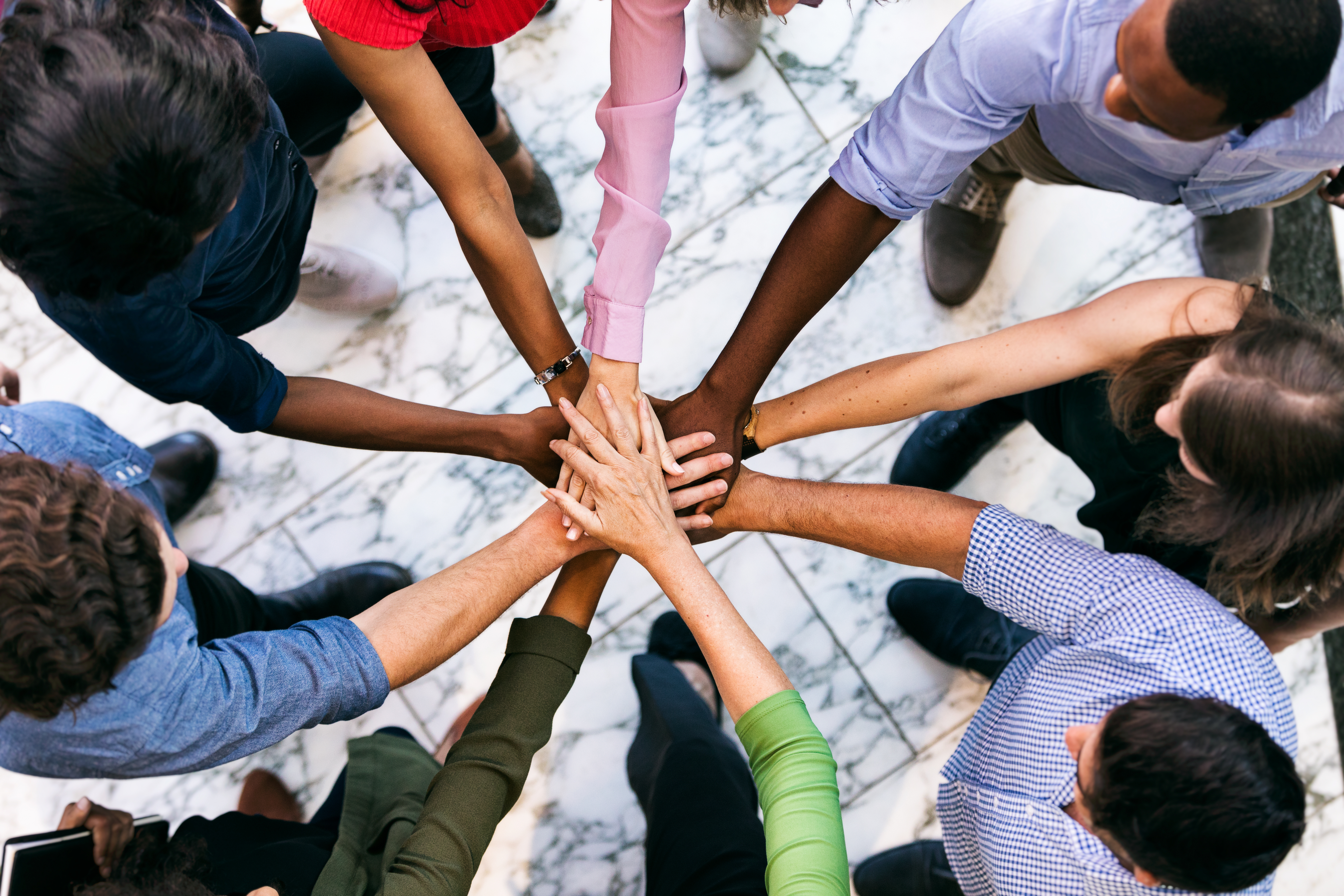 Diverse team joining hands