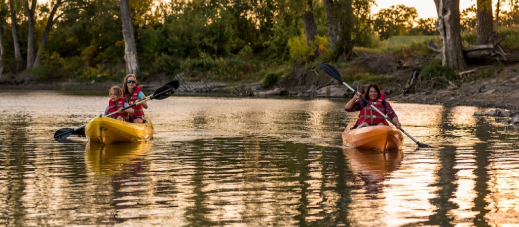 two people kayaking at sunset