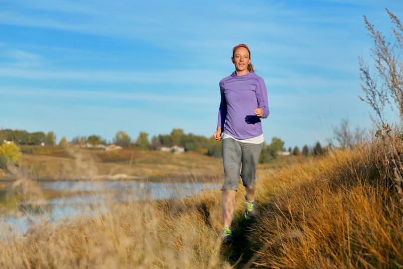 Lady hiking near a river.